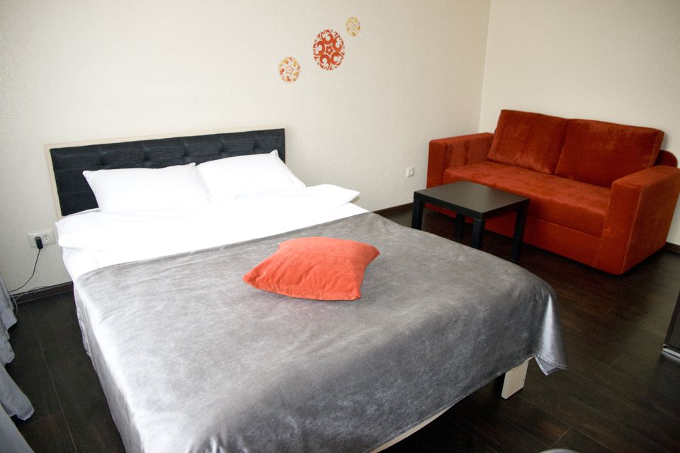 Яркая теплая студия Люкс с красным диваном