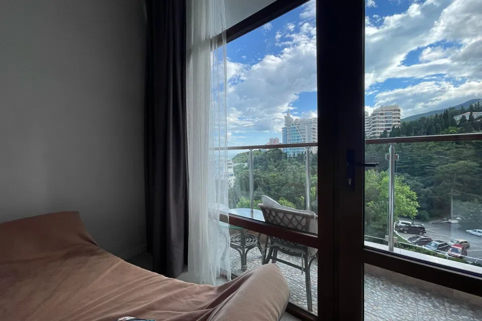 С видом на море, в парковой зоне на набережной.